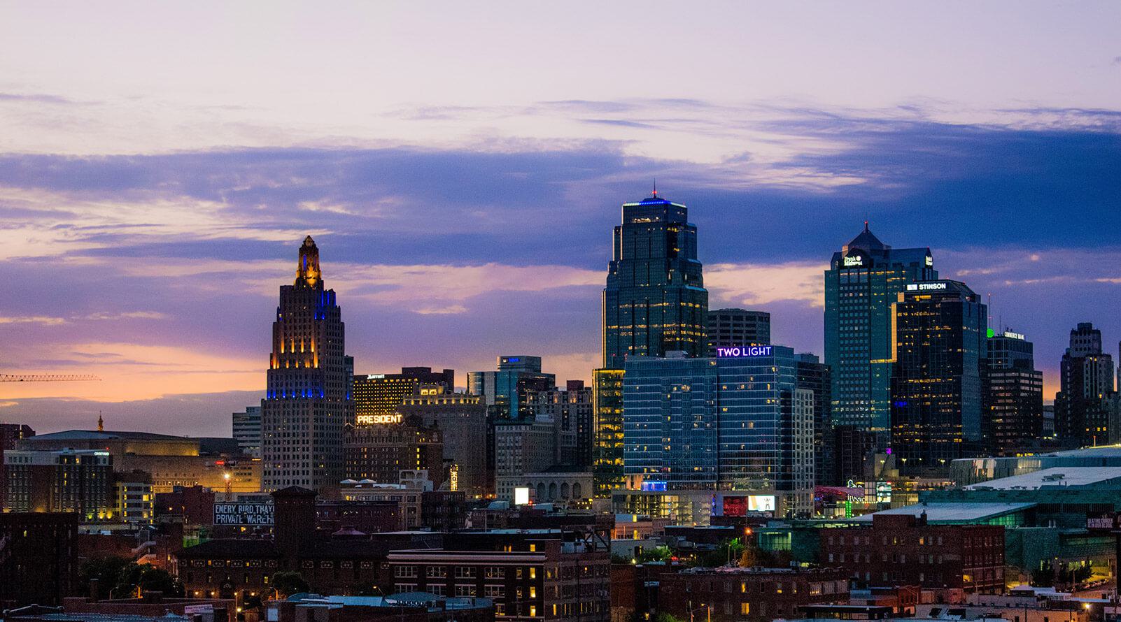 Kansas City skyline at dusk with lights in the building windows