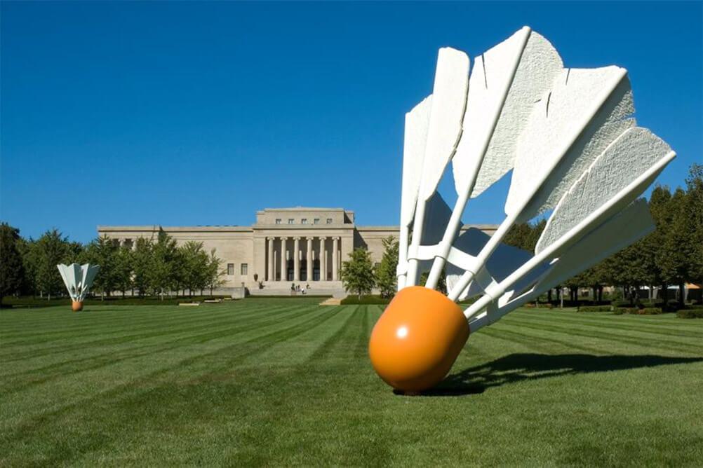Giant sculpture of badminton birdie on lawn with museum in background