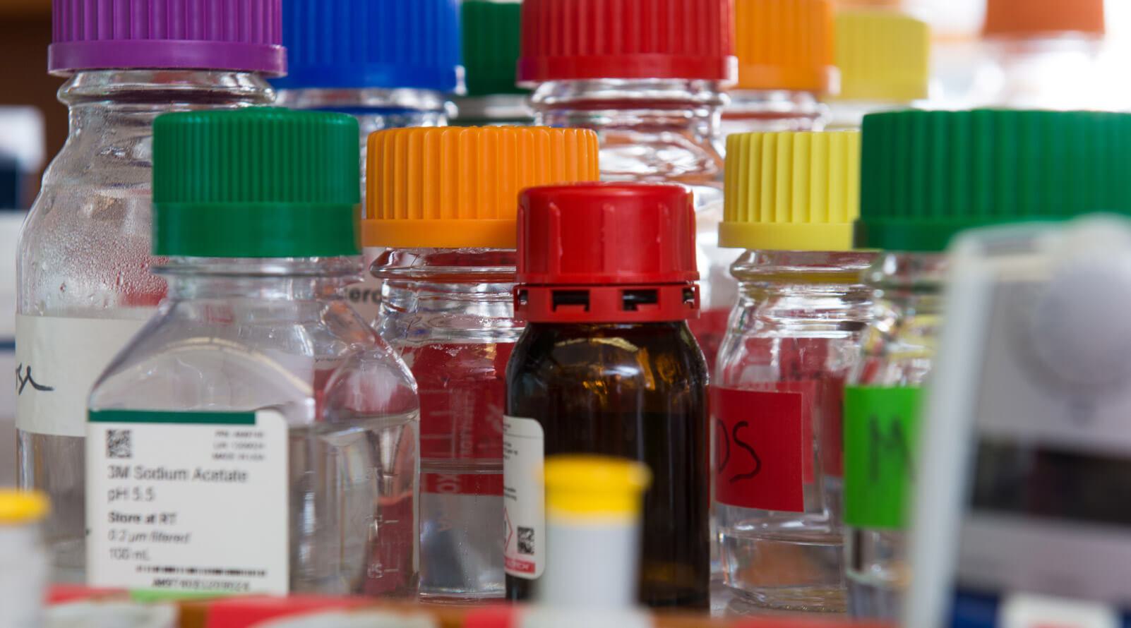 Close up of small clear glass containers with colorful lids