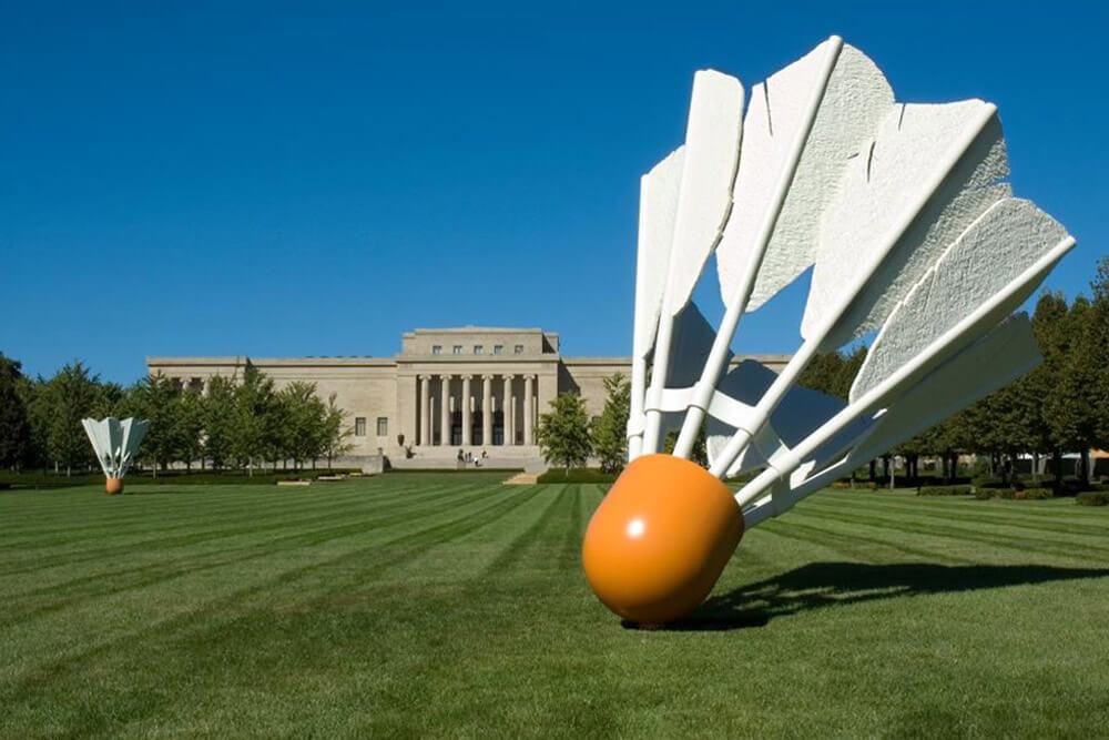 A giant sculpture of a badminton birdie on the lawn in front of museum building