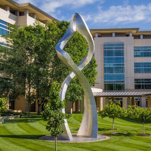 Photo of a shiny double helix statue on the grounds of the Stowers Institute