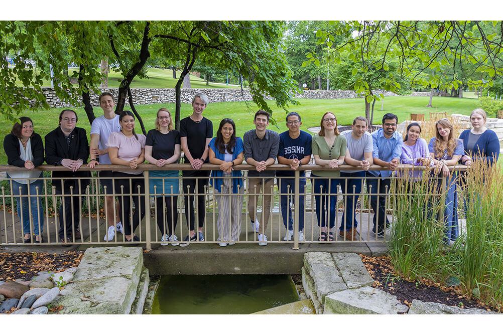 Dr. Julia Zeitlinger's lab team standing on a bridge above a small stream at the Stowers Institute in Kansas City
